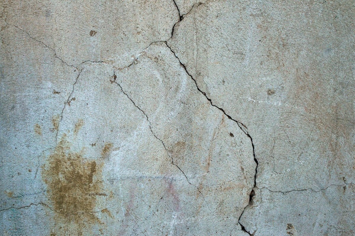 Réseau de fissures sur un enduit de façade ancien
